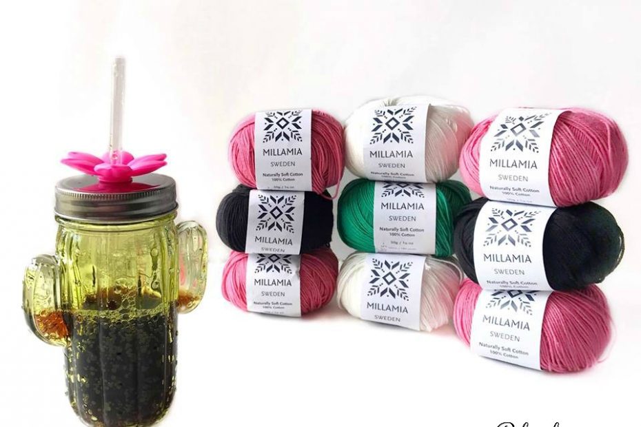 Stacks of yarn balls next to a cactus cup