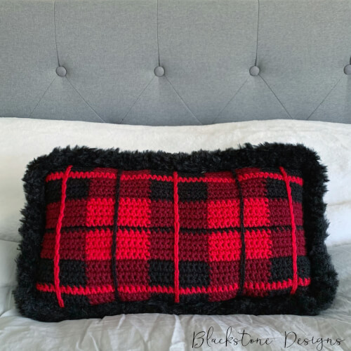 Red, Burgundy, and Black Plaid Pillow with black fur border on gray bedding