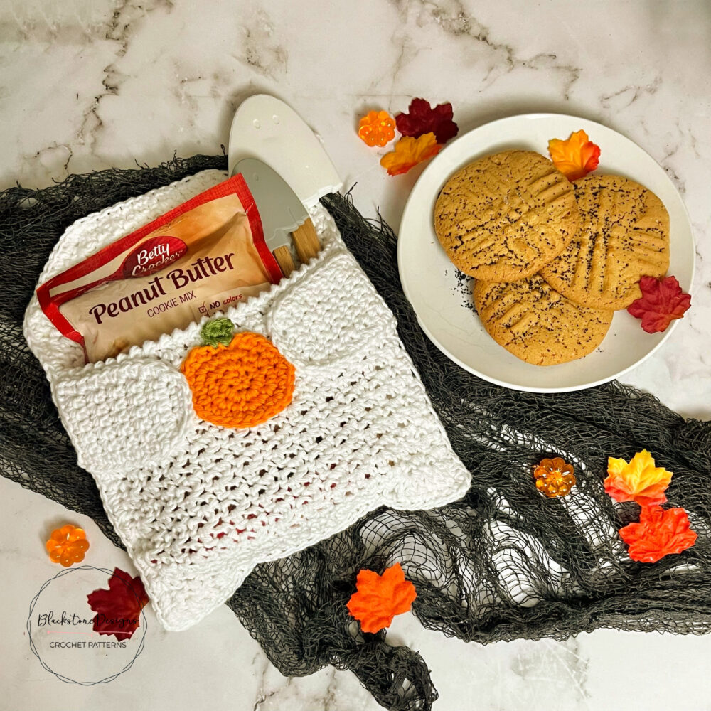 Crochet Ghost Pot Holder with cookie mix in the Pocket, the crochet Ghost is holding a pumpkin
