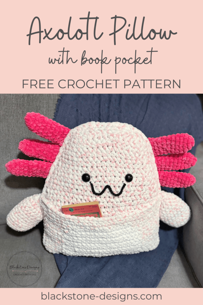 Crochet Axolotl Pillow with Book Pocket belly, made with light pink yarn for the body and dark pink for the external gills