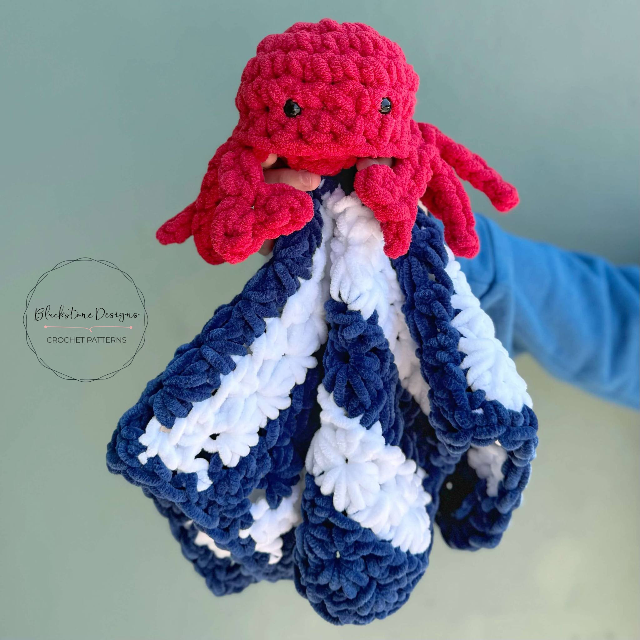Feeling Crabby Lovey Blanket Crochet Pattern featuring a red amigurumi crab on a blue and white striped blanket