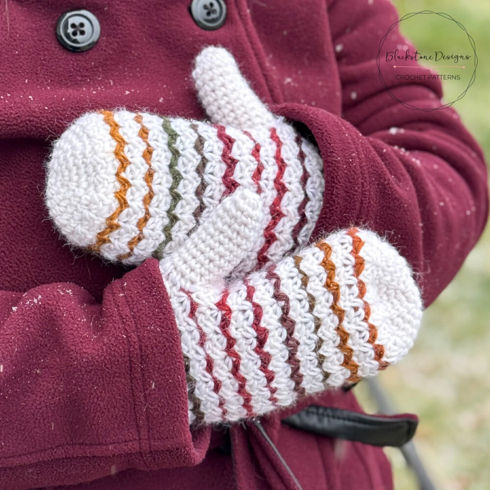 White crochet mittens with colorful stripes with burgundy pea coat