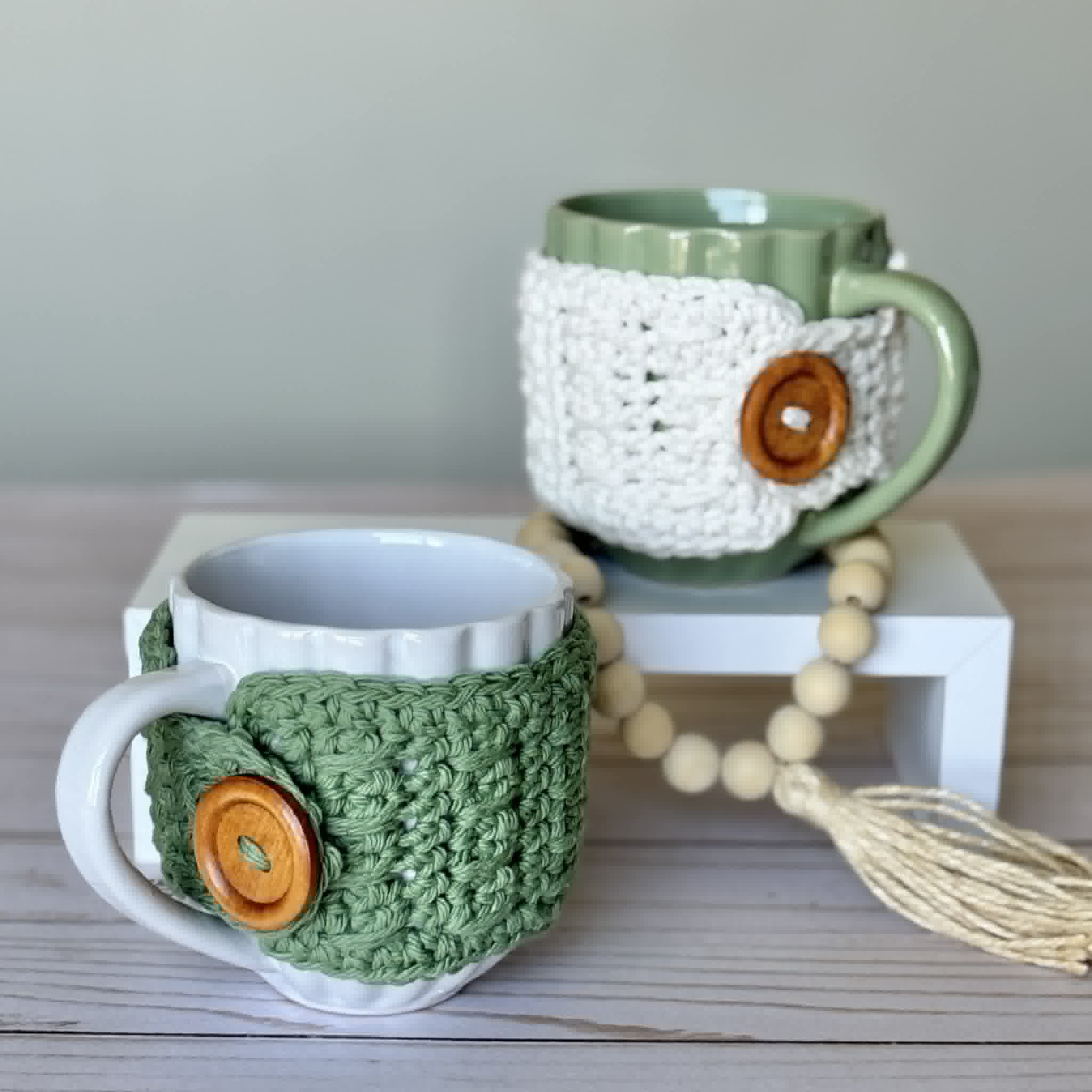 Handmade crochet mug cozy with textured spike stitch pattern and button closure