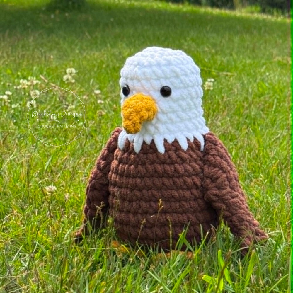 Close-up of a handmade Bald Eagle Amigurumi crochet toy featuring a white head, brown body, and yellow beak.